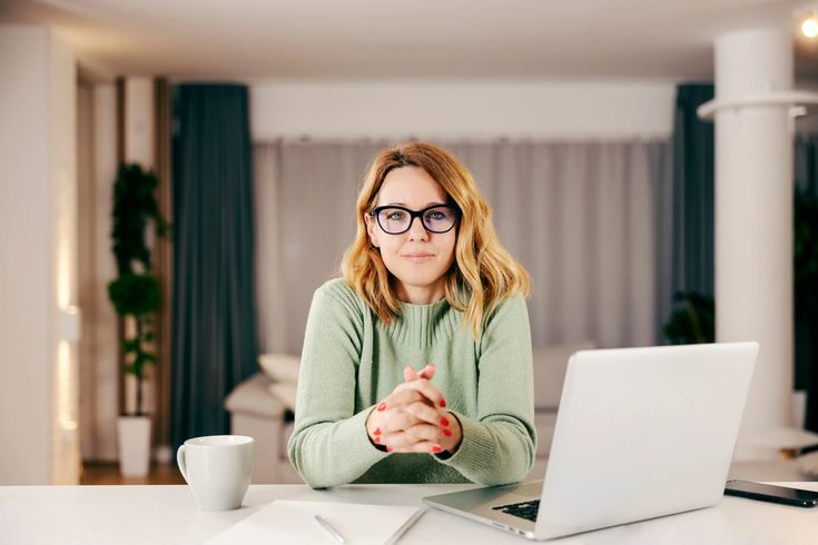 Diverse group of professionals collaborating efficiently, with some visible as remote workers on screens, symbolizing a modern scalable team strategy without constant hiring.